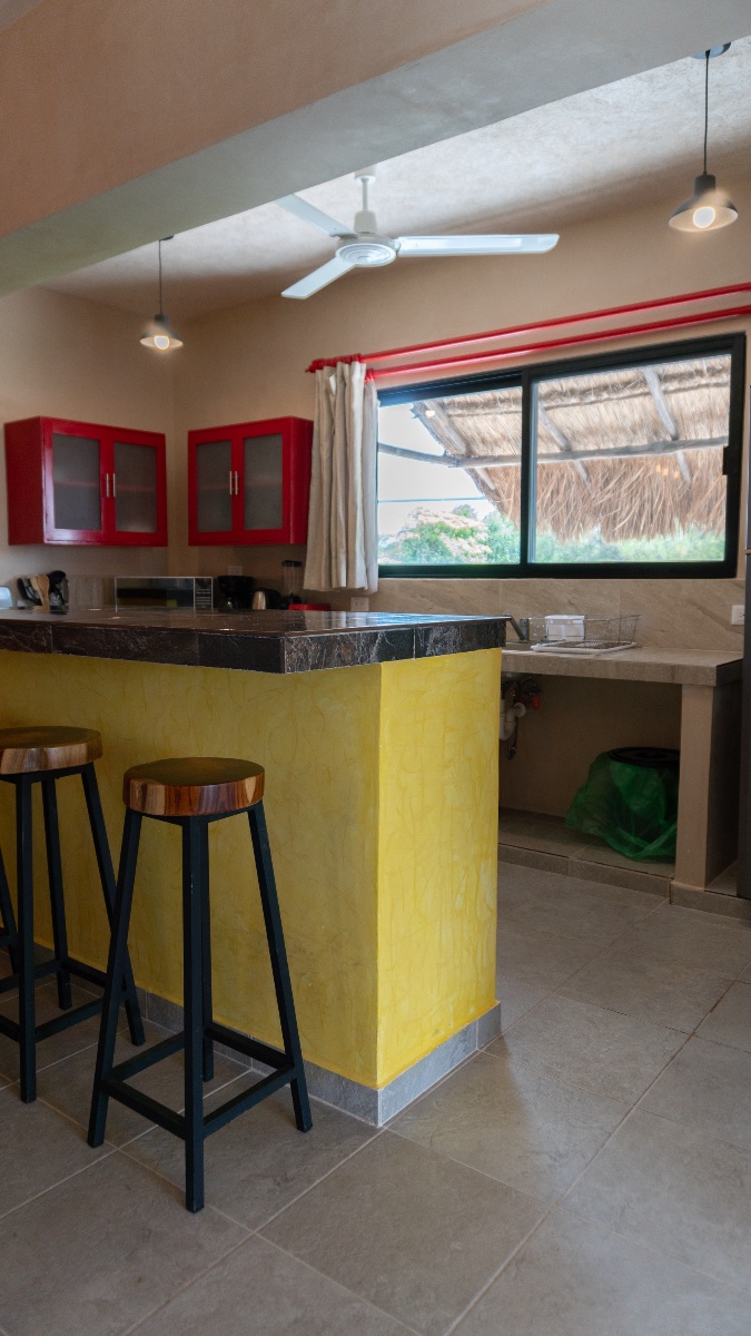 Cocina equipada con barra y bancos en departamento boutique Kinila, Progreso Yucatán