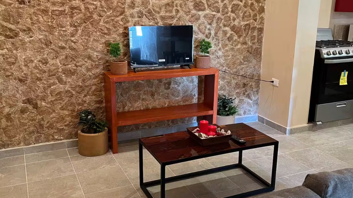 Sala con acabados en chukum y Smart TV en Kinila Apartments, Chicxulub Progreso